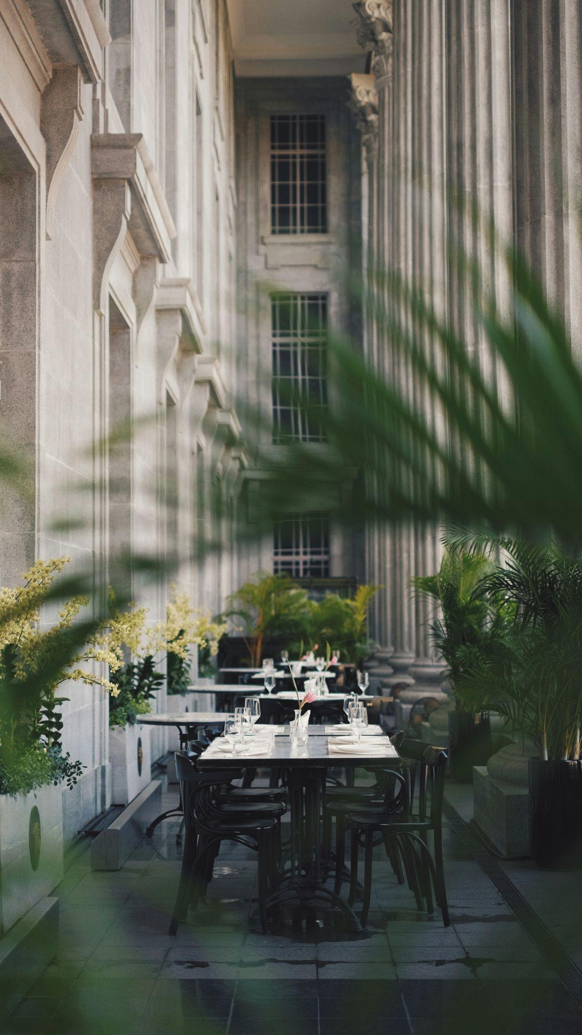 Outdoor terrace dining set against classical architecture