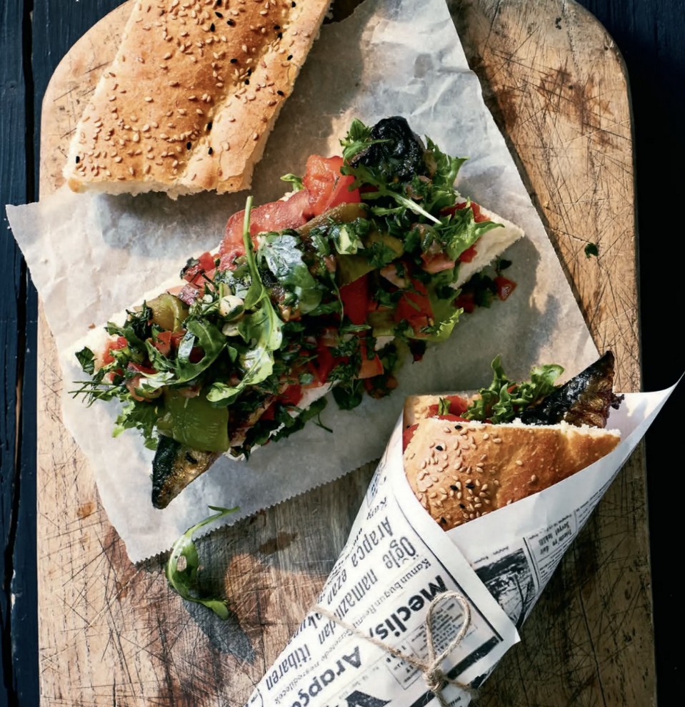 Open street-style sandwich on a wooden board