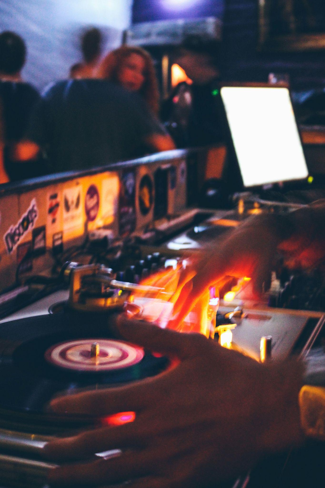 DJ mixing desk lit by warm amber light