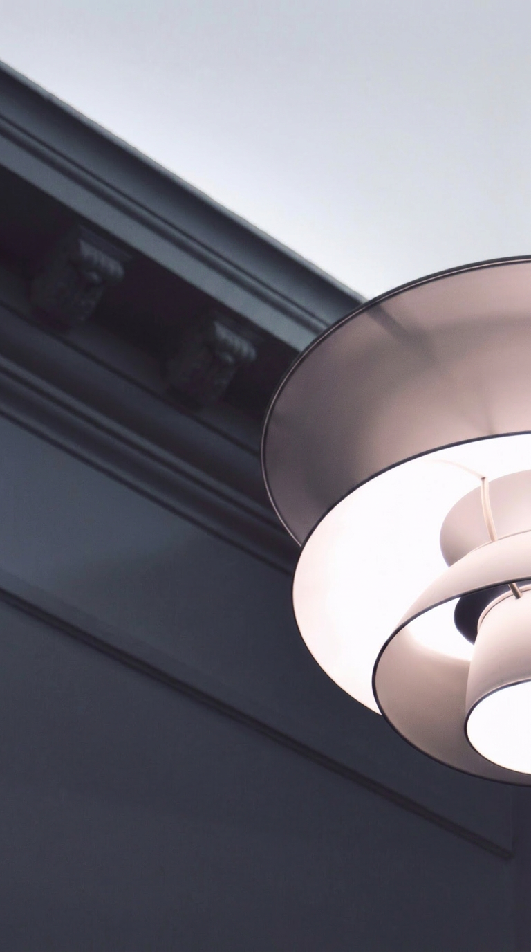 Signature hospitality interior with sculpted pendant lamp and deep navy ceiling moulding